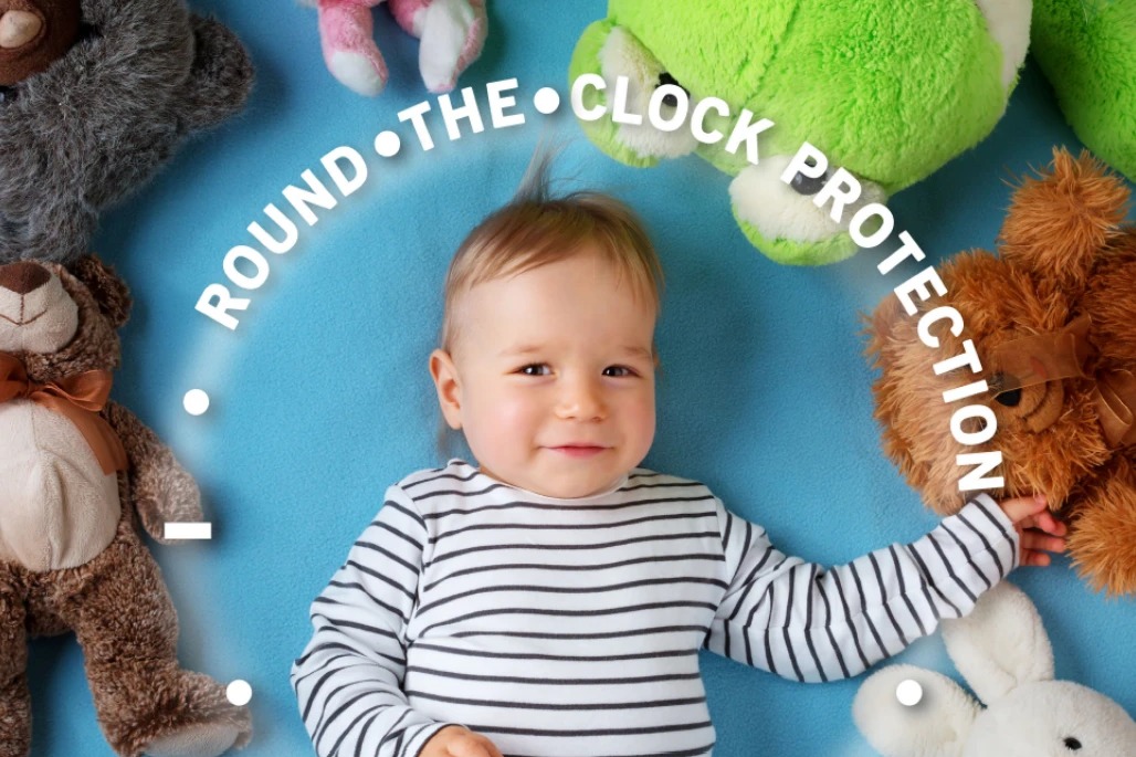 Evrysdi 'Round the Clock Protection' ad detail: a baby lying among plush toys inside a circular 'Round the Clock Protection' clock graphic